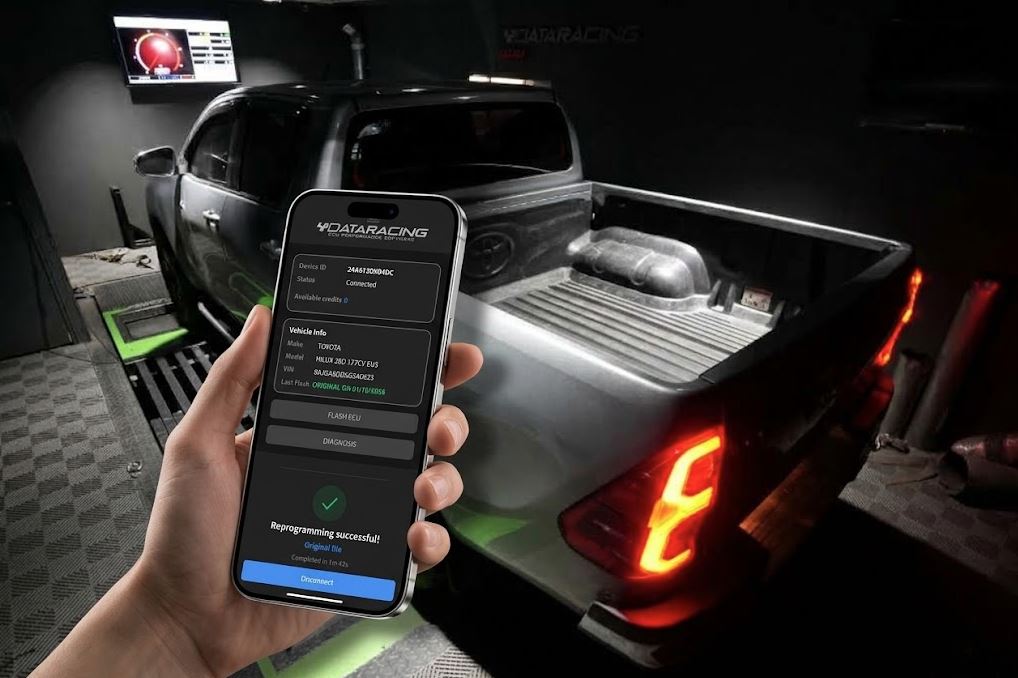 Customer holding a smartphone running a dealer-branded ECUNEX app next to a tuned pickup truck